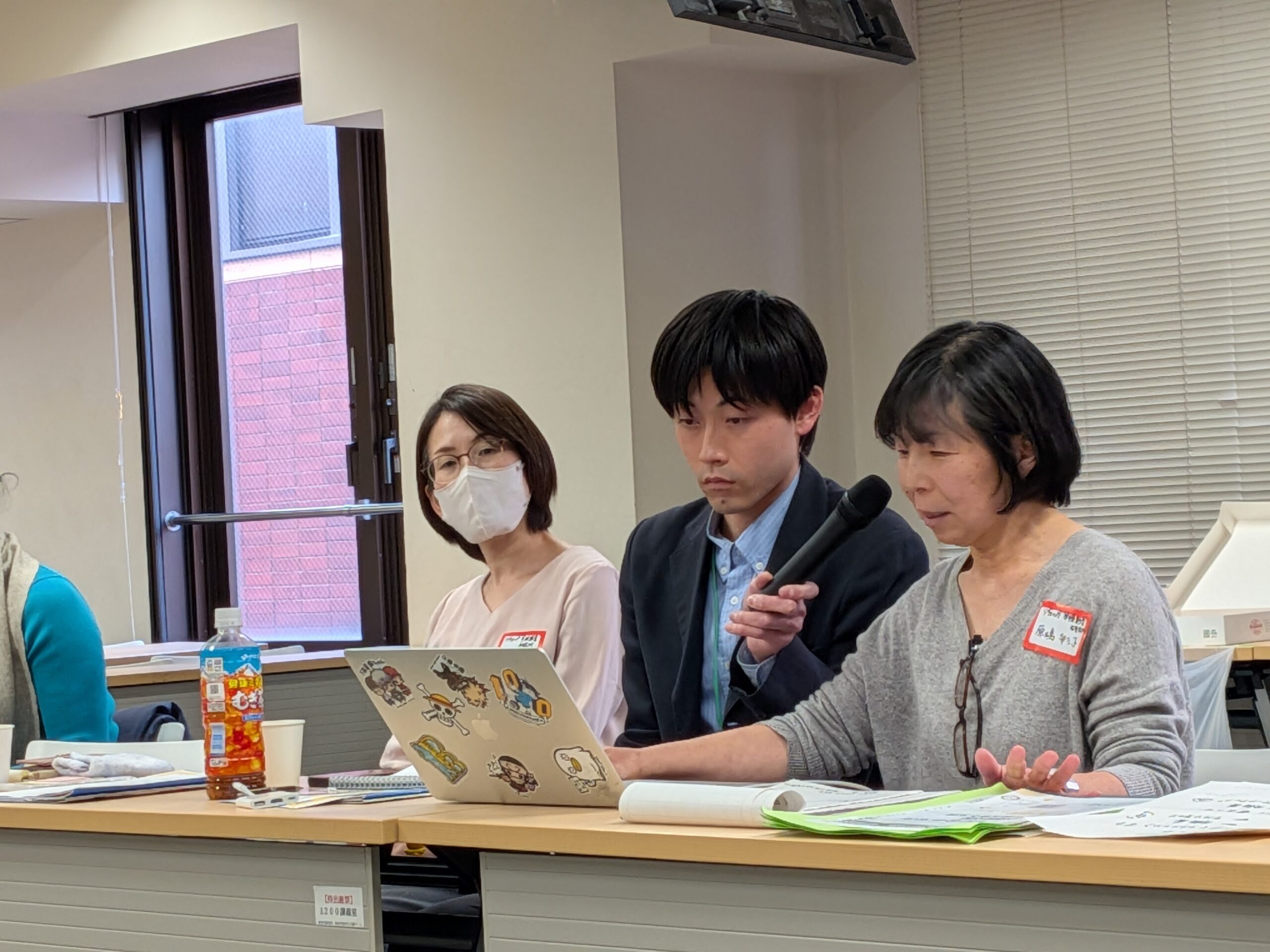 リヴォルヴ学校教育研究所の実践報告の様子。3名の登壇者がマイクを持ちながら発表している